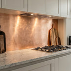Modern kitchen with copper backsplash and marble countertop

