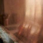 Brushed copper splashback close up behind a marble worktop