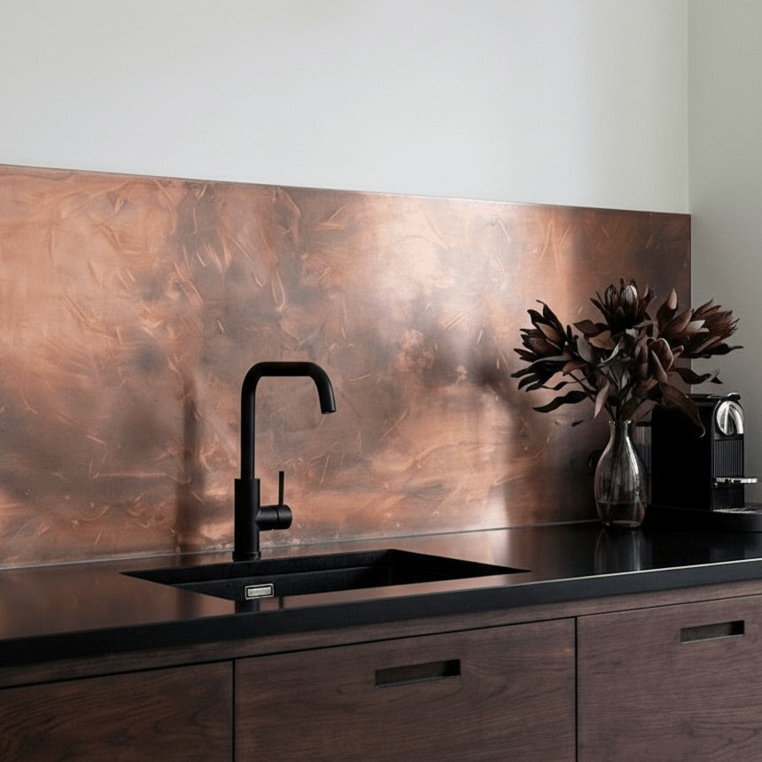 Modern kitchen with black faucet, copper backsplash, and dark wood cabinets.